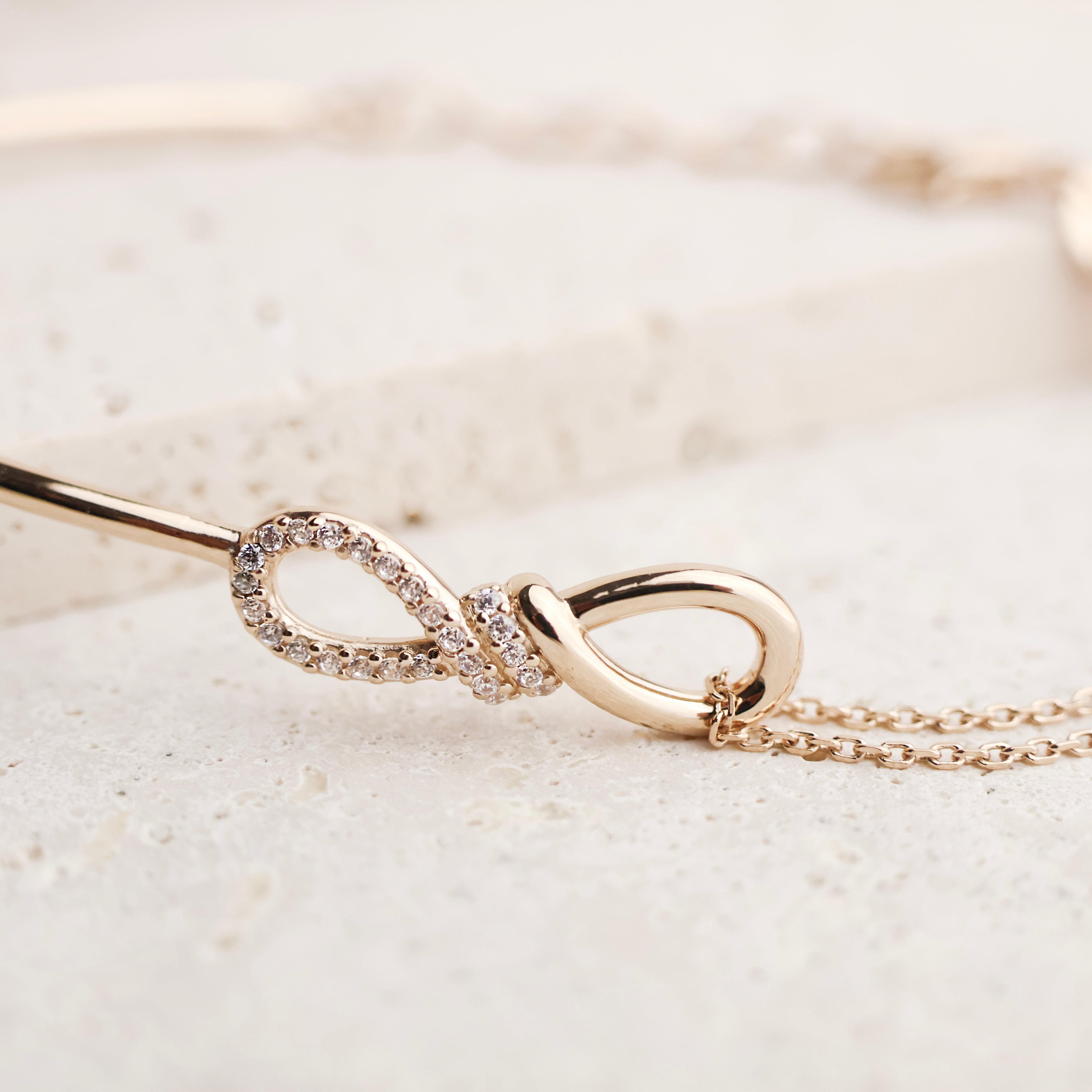 Bracelet Noor en plaqué or 18 carats – Un design unique avec un pendentif symbole de l'infini, serti d'oxydes de zirconium scintillants. Monté sur une chaîne maille forçat de 18 cm pour un style moderne et raffiné. Conçu en laiton avec un placage 3 microns, poinçonné pour garantir qualité et durabilité. Livré dans une élégante boîte Joyamada ou un pochon en coton bio.